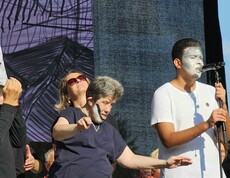 Menschen mit Gesichtsbemalung auf einer Bühne mit Mikrofon