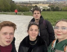im Vordergrund vier june Leute, im Hintergrund Schloss Schönbrunn