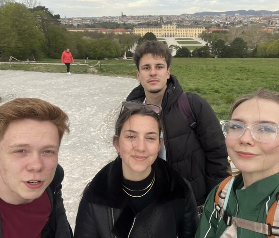 im Vordergrund vier june Leute, im Hintergrund Schloss Schönbrunn