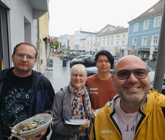 Vier Personen mit Körberl mit Steinen