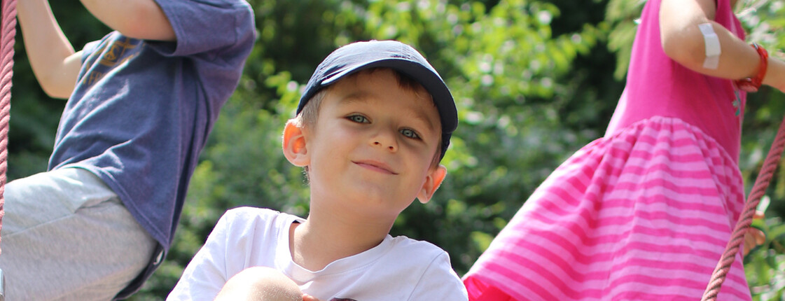 Nah dran: Wenn Kindern alle Türen offen stehen Drei Kinder schaukeln auf einer Nestschaukel