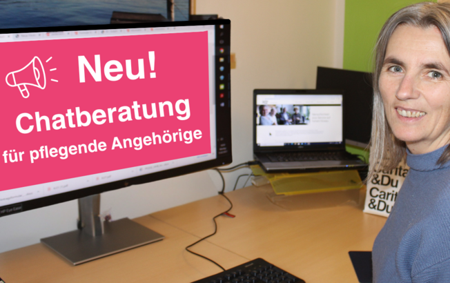 Eine Frau sitzt am Schreibstisch und lächelt in die Kamera. Am Bildschrim des Computers ist zu lesen: Neu Chatberatung für Pflegende Angehörige
