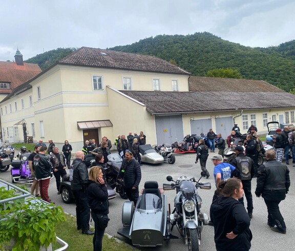 Große Gruppe von Biker*innen und Teilnehmenden bei Beiwagenausfahrt am Caritas-Standort Engelhartszell