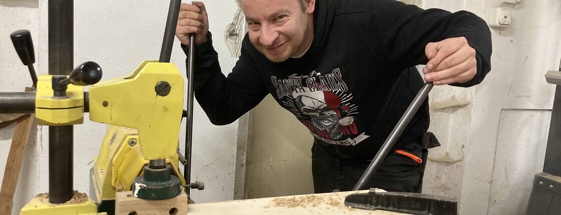 Mann arbeitet an einer Holzbearbeitungsmaschine