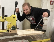 Mann arbeitet an einer Holzbearbeitungsmaschine