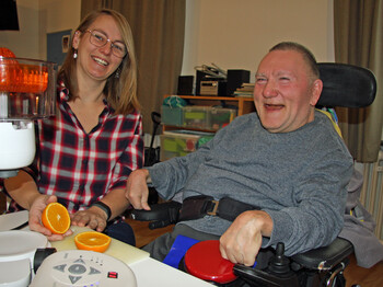 Frau links im Bild, Mann im Rollstuhl rechts im Bild