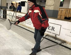 Ein Schütze setzt mit seinem Eisstock zum Schießen an. 