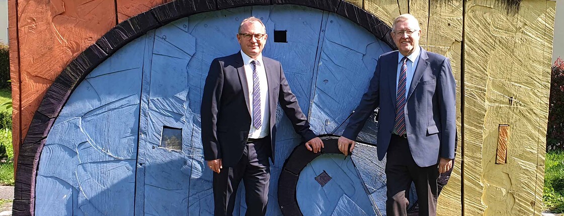 Zwei Männer vor einer künstlerischen Schnecke