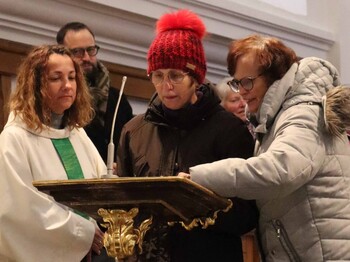 Drei Personen am Rednerpult. 