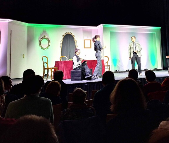 Drei Schauspieler auf einer Bühne - im Vordergrund sitzt das Publikum