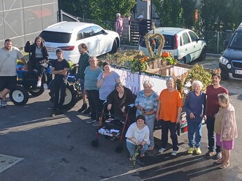 Viele Leute stehen vor einem Erntedankwagen