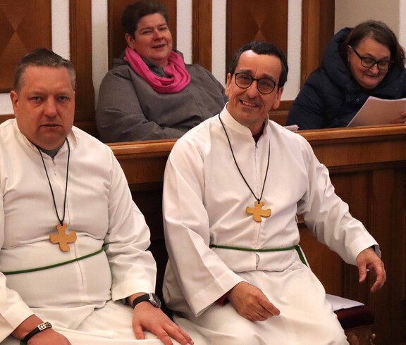 Vier Personen im Chorgestühl einer Kirche