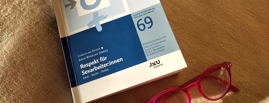 Buch liegt am Boden, daneben eine rote Brille