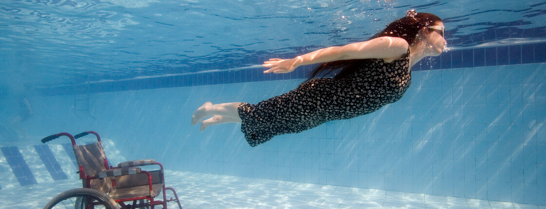 A disabled diver breaks free from her wheel chair in swimming pool in Sharm el Sheikh Egypt.