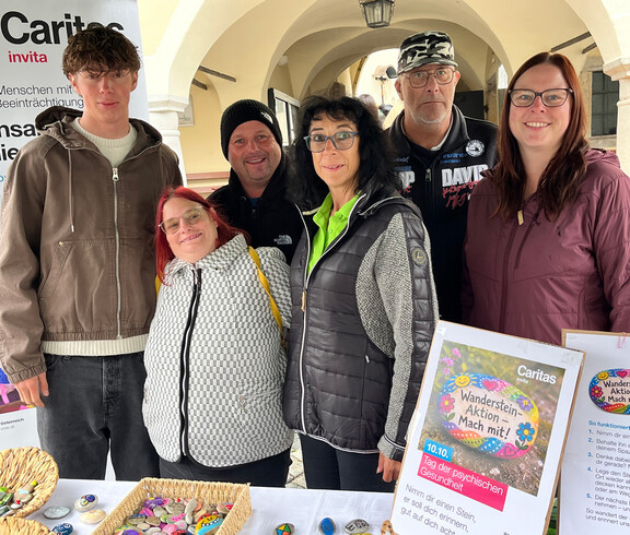 Sechs Personen mit ihrem Steine-Stand