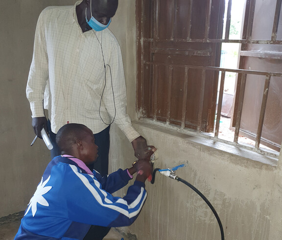 Zwei Männer schließen die Gasleitung, die an der Wand montiert wird, an.