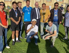 Mehrere Personen stehen am Fussballfeld zusammen.