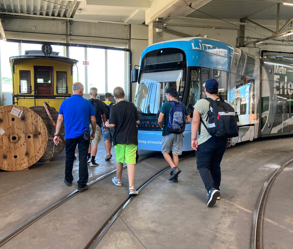 Action: Burschen gehen auf Straßenbahn zu