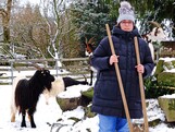 Eine Frau steht in einem Ziegengehege