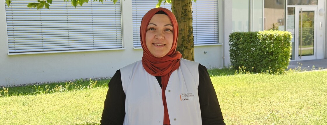 Frau mit rotem Kopftuch und einer weißen Caritas Pflege Weste