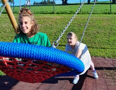 Zwei Mädchen spielen auf einer Schaukel