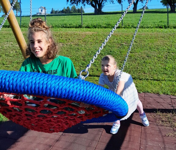 Zwei Mädchen spielen auf einer Schaukel