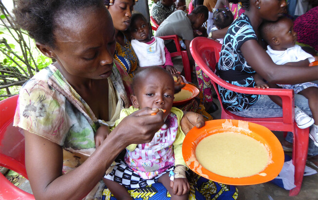 Mütter sitzen mit ihren Babys in einer Ernährungsstation in Kinshasa, DR Kongo, wo sie Nahrungshilfe und Unterstützung erhalten.