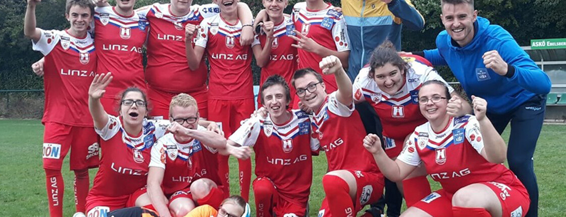 Gruppenfoto der Fußballmannschaft in roten Dressen