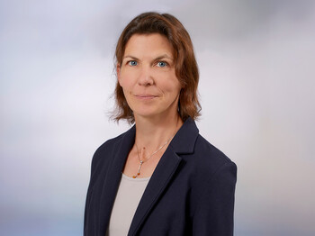 Eine Frau mit Schulterlangen braunen Haaren, einem Sakko und T-Shirt im Portrait