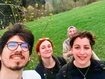 Eine Gruppe von jungen Menschen machen ein Selfie auf einer grünen Wiese