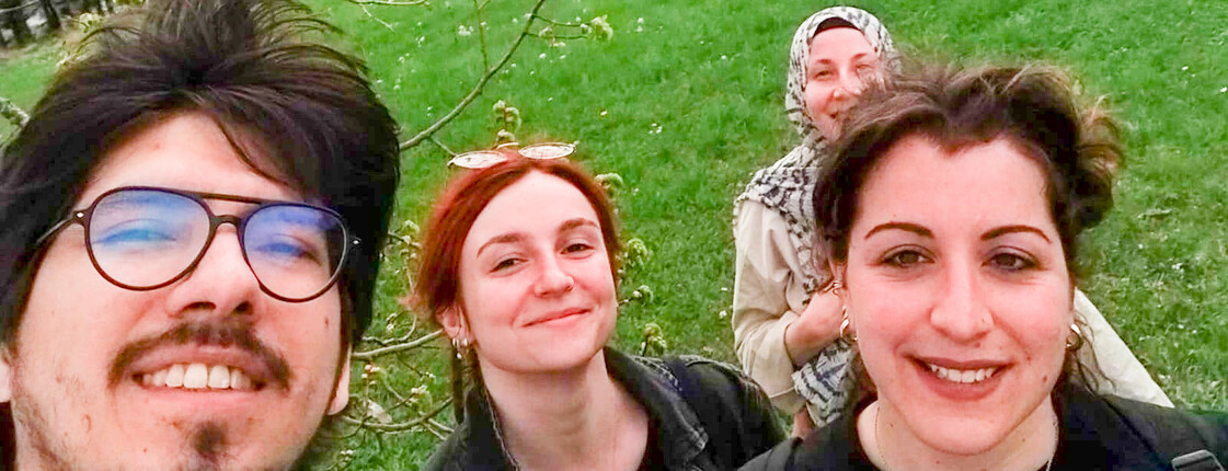 Eine Gruppe von jungen Menschen machen ein Selfie auf einer grünen Wiese