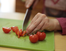 Tomaten werden mit einem Messer kleingeschnitten