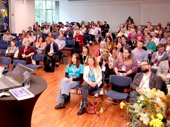 Caritas Forum 2025: KI & Du? Visionen für ein sozial-digitales Morgen Ein Blick in einem vollgefüllten Saal, wo die Menschen auf Stühlen sitzen.
