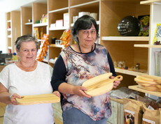 Zwei Frauen halten selbst gemachte Holz-Jausen-Brettl in die Kamera.