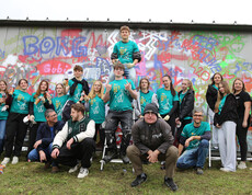 Eine Gruppe von Jugendlichen vor einer Wand mit Grafitti