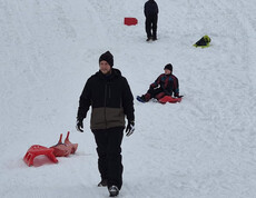 Mehrere Jugendliche mit ihren Rodeln im Schnee
