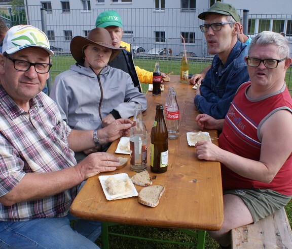 Sechs  Menschen sitzen an einem Tisch.