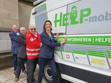Vier Personen stehen vor einem Bus.