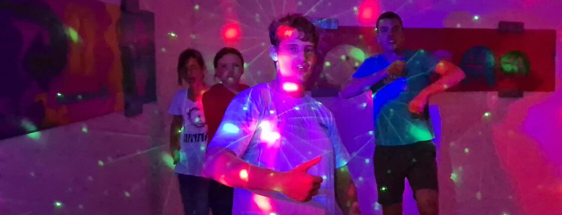 Jugendliche in bunt belechtetem Partykeller