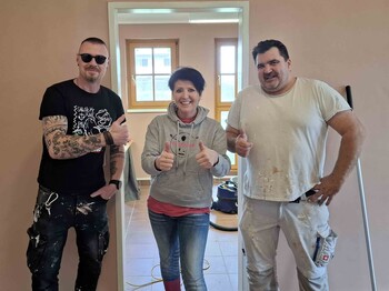 Drei Personen in einem frisch gestrichenen Raum