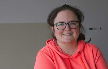 Ein Portrait Bild von einer Frau mit braunen Haaren und Brille.