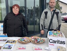 Zwei Personen mit Steinen und Caritas-Sackerl