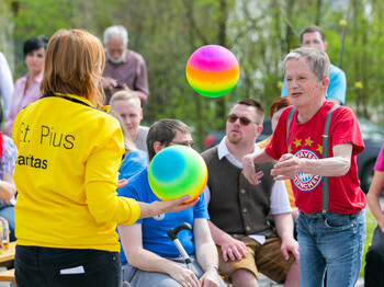 Bunte Menschenmenge, zwei Leute spielen mit zwei bunten Bällen