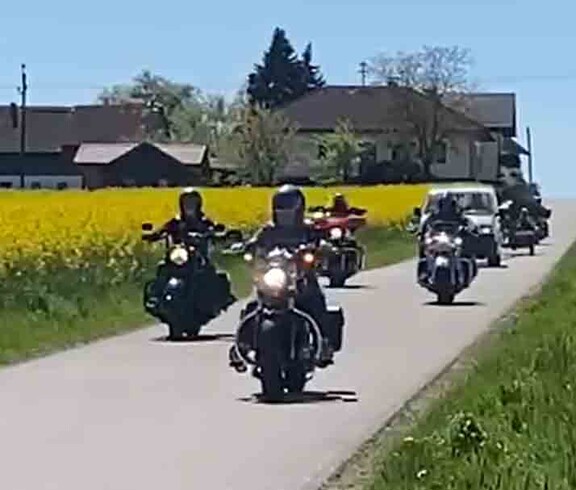 Motorradfahrer und Maibaum-Transport
