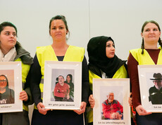 Vier Frauen halten jeweils ein Bild in der Hand. Auf den Bildern sind Personen abgebildet. 