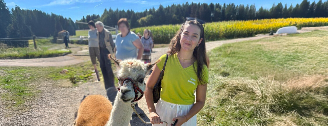 Junge Frau mit Alpaka an der Leine
