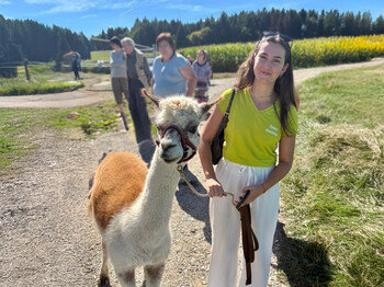 Junge Frau mit Alpaka an der Leine