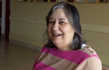 Portraitbild von einer Frau mit gestreiften Pulli und einer Schere in der Hand