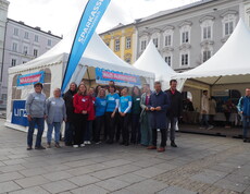Eine Gruppe an Personen stehen vor einem Pagodenzelt.
