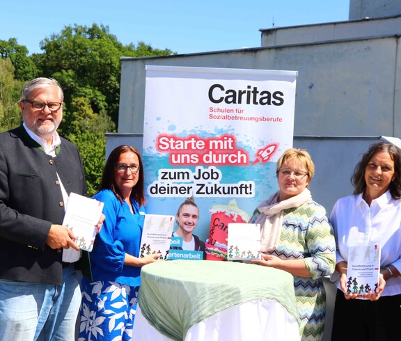 Fünf Personen präsentieren ein Buch.